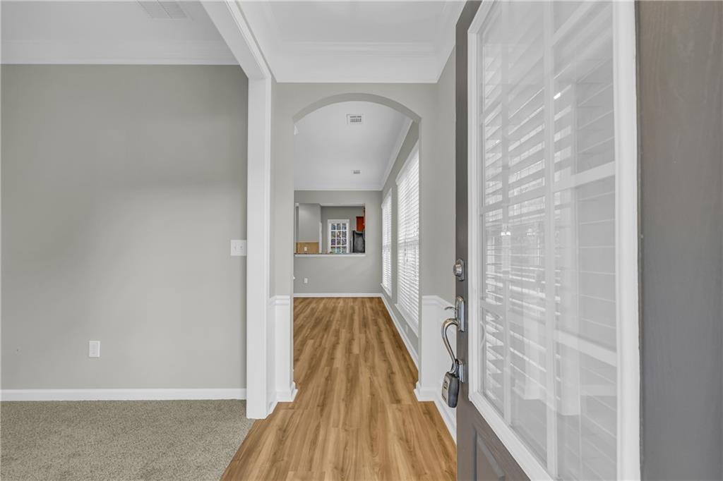 6116 Longleaf Drive Hoschton, GA 30548 - Photo 4 of 46 a view of a hallway with wooden floor and staircase