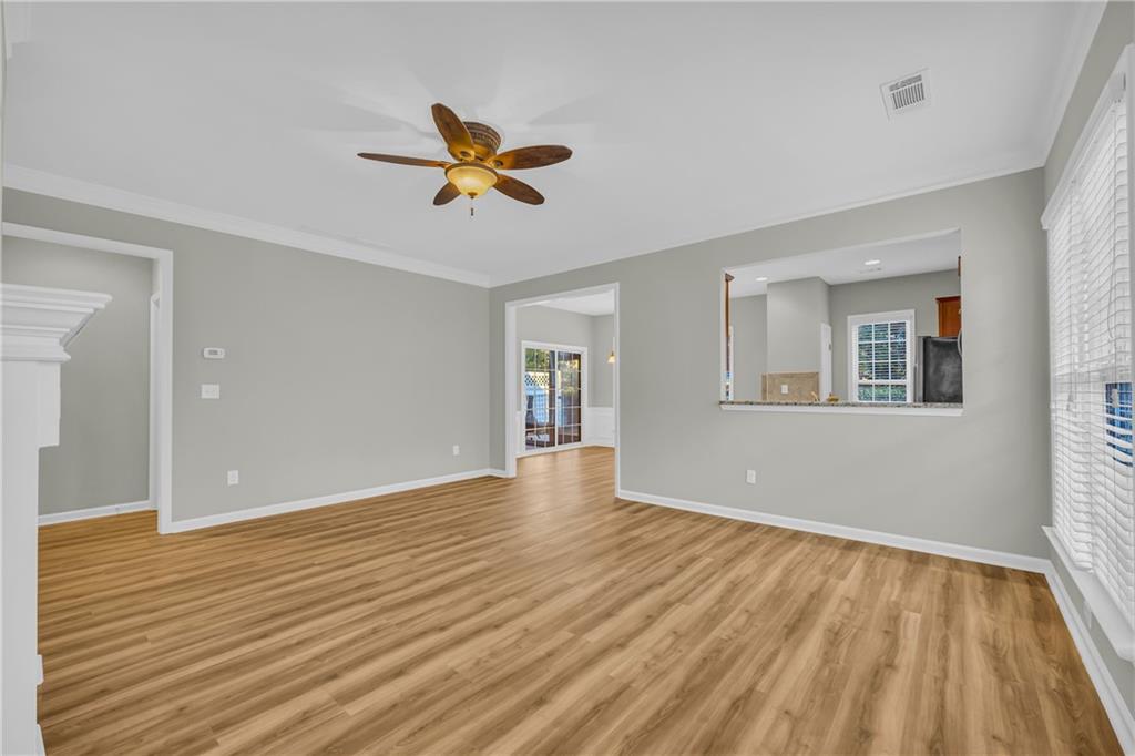 6116 Longleaf Drive Hoschton, GA 30548 - Photo 6 of 46 a view of empty room with wooden floor and fan