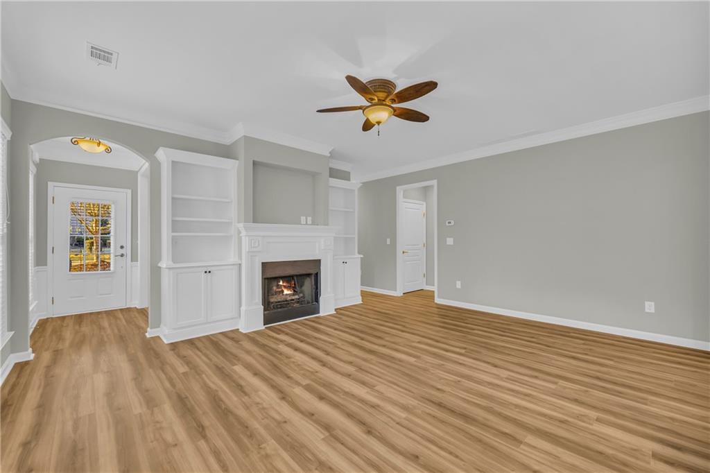 6116 Longleaf Drive Hoschton, GA 30548 - Photo 7 of 46 a view of empty room with wooden floor and fireplace