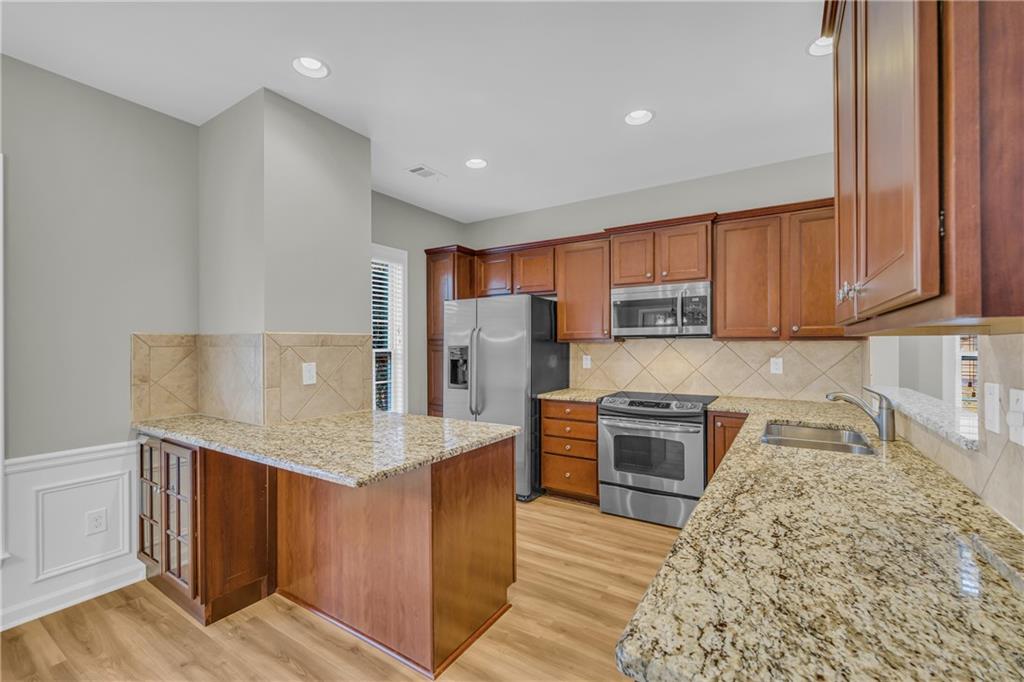 6116 Longleaf Drive Hoschton, GA 30548 - Photo 10 of 46 a kitchen with stainless steel appliances granite countertop a refrigerator sink and cabinets