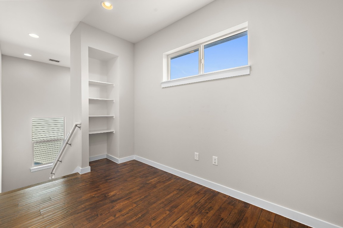 5616 South 1st Street, Unit 31 Austin, TX 78745 - Photo 13 of 21 a view of an empty room with wooden floor and a window