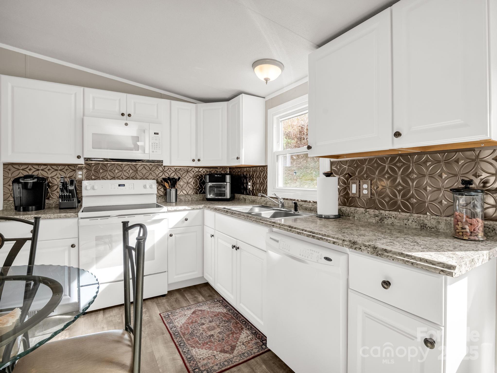 106 Hazy Day Swannanoa, NC 28778 - Photo 7 of 30 a kitchen with granite countertop white cabinets sink and white appliances