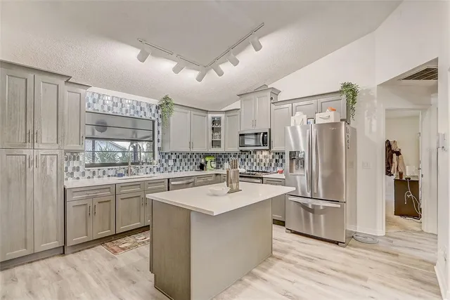 a kitchen with stainless steel appliances a sink stove and refrigerator