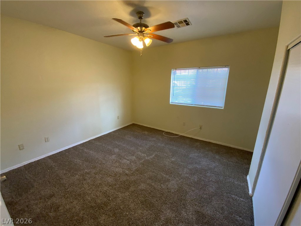 4730 East Craig Road, Unit 1091 Las Vegas, NV 89115 - Photo 11 of 14 A comfortable bedroom with plush carpeting and a ceiling fan, offering a tranquil retreat.