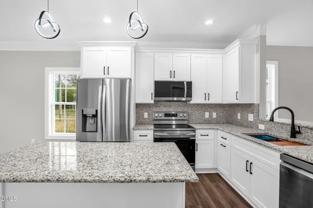 a kitchen with granite countertop a stove and a refrigerator