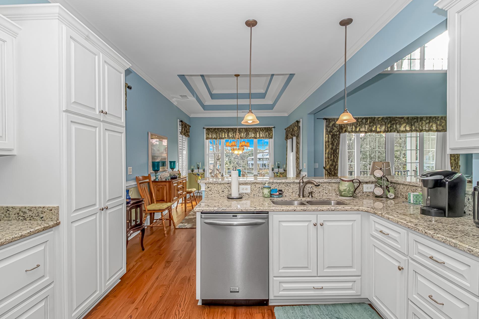 309 North Myrtle Drive Surfside Beach, SC 29575 - Photo 8 of 40 Kitchen featuring white cabinets, dishwasher, a tray ceiling, light stone countertops, and crown molding