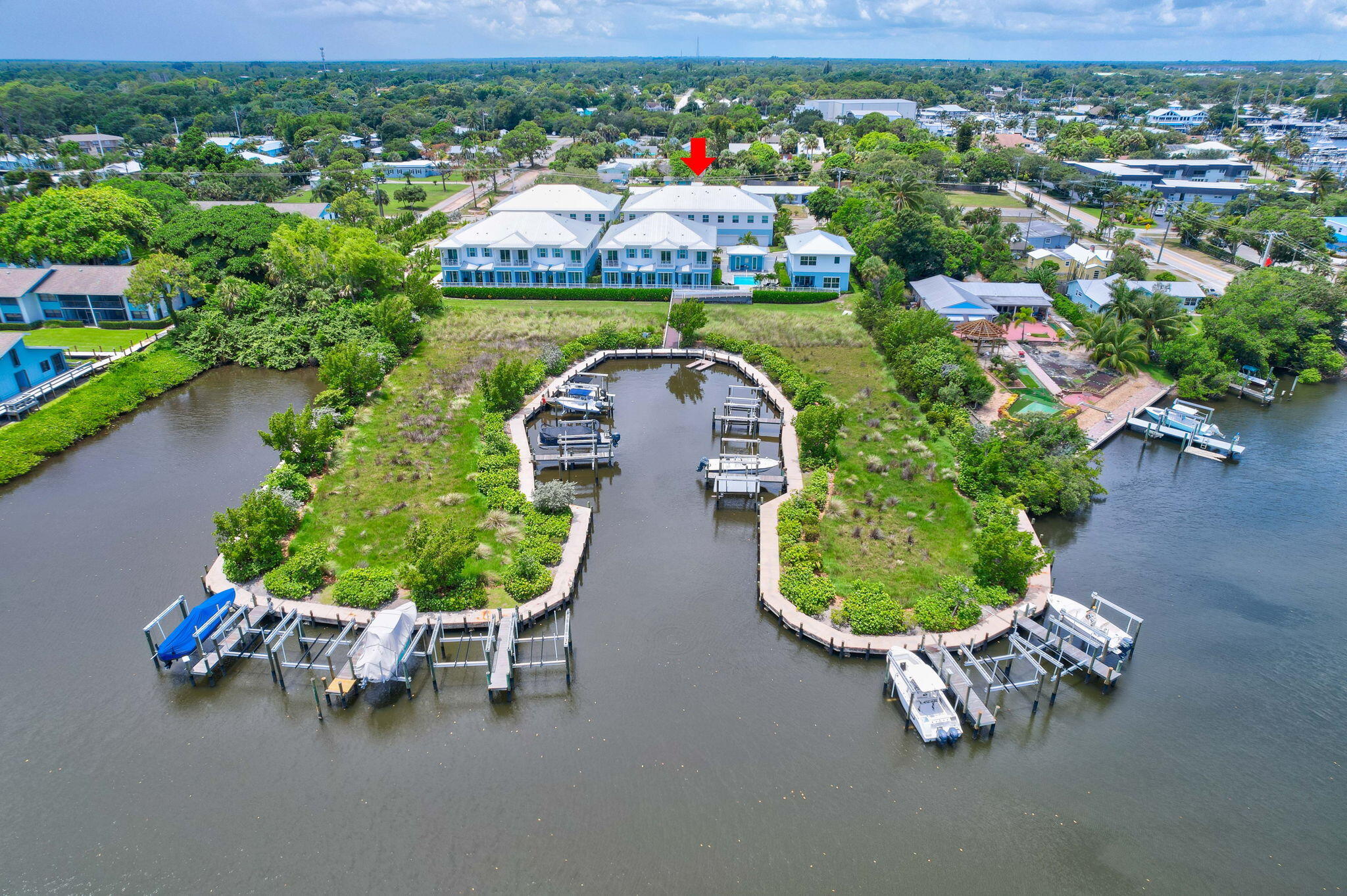 an aerial view of a house with a garden and lake view
