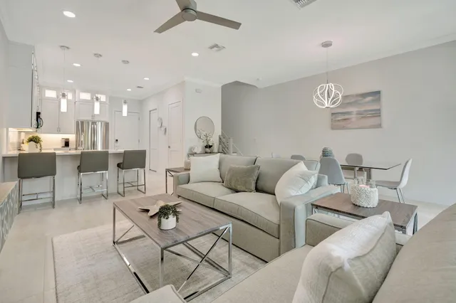 a living room with furniture and a view of kitchen