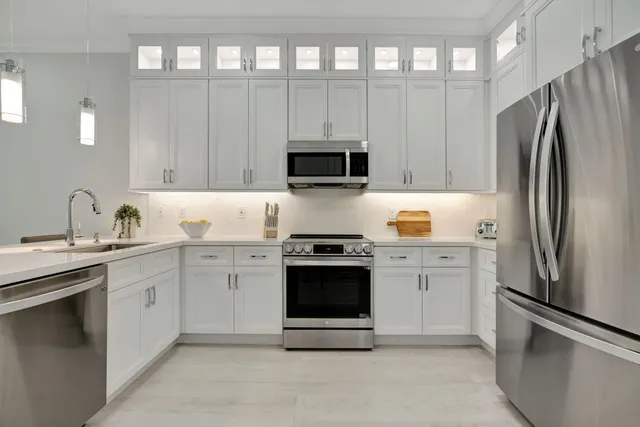 a kitchen with stainless steel appliances granite countertop a refrigerator stove and sink