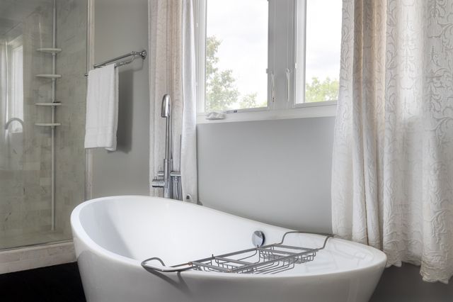 a white bath tub sitting in a bathroom next to a window
