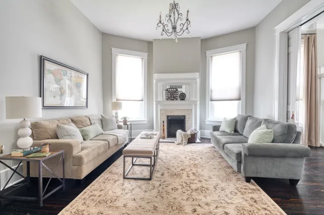 a living room with furniture a fireplace and a window