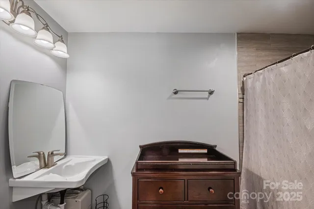 a kitchen with stainless steel appliances granite countertop a stove a sink a refrigerator white cabinets and chairs