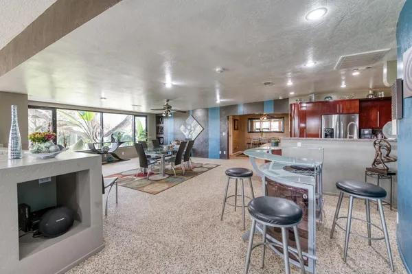 a kitchen with refrigerator and chairs
