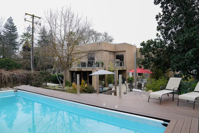 a view of a patio with couches table and chairs with wooden floor and fence