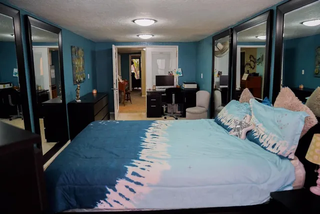 a bedroom with bed and two windows