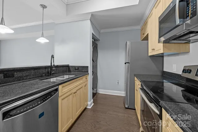 a kitchen with stainless steel appliances granite countertop a sink a stove and a refrigerator