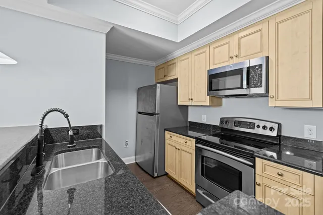 a kitchen with stainless steel appliances granite countertop a stove microwave and sink
