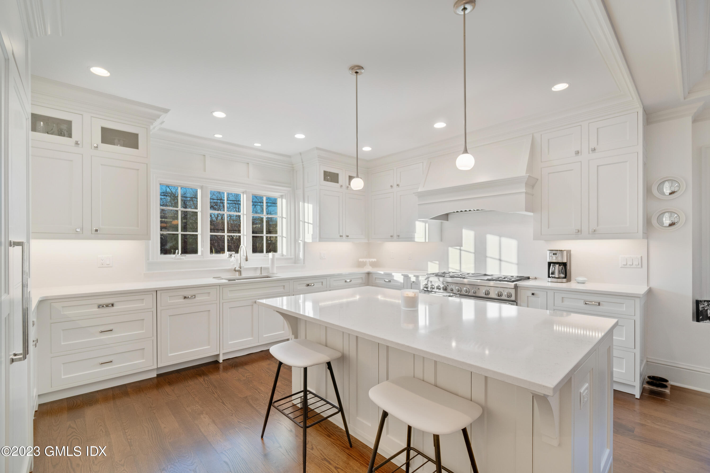 3 Orchard Place, Unit A Greenwich, CT 06830 - Photo 4 of 24 a large kitchen with kitchen island a dining table chairs sink and white cabinets
