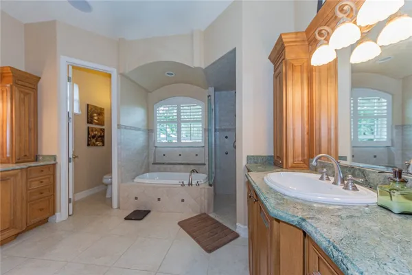 a en suite bathroom with a granite countertop sink and a mirror
