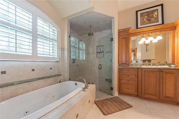 a bathroom with a tub a sink and a large mirror