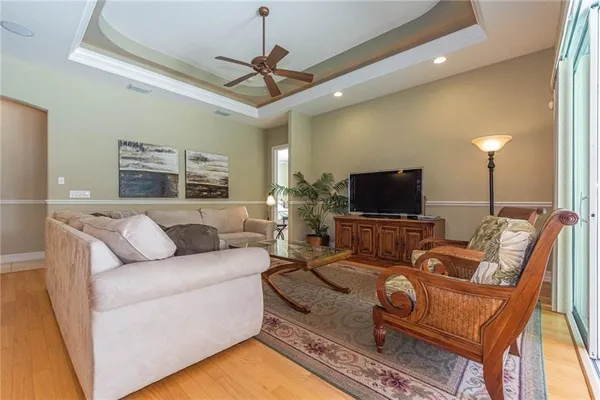 a living room with furniture a flat screen tv and a chandelier