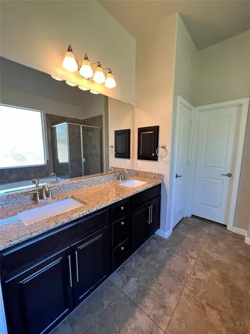a spacious bathroom with a granite countertop sink and a mirror