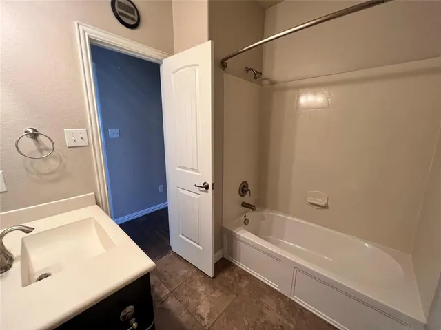 a bathroom with a tub sink vanity and toilet