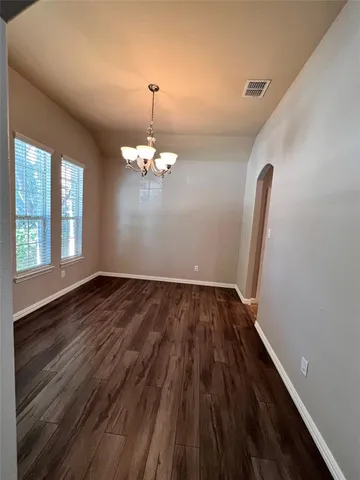 a view of a room with wooden floor and chandelier