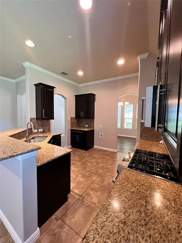 a large kitchen with stainless steel appliances granite countertop a sink stove and refrigerator