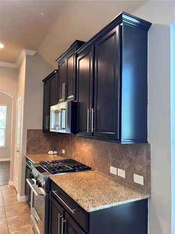 a kitchen with granite countertop a stove and a refrigerator