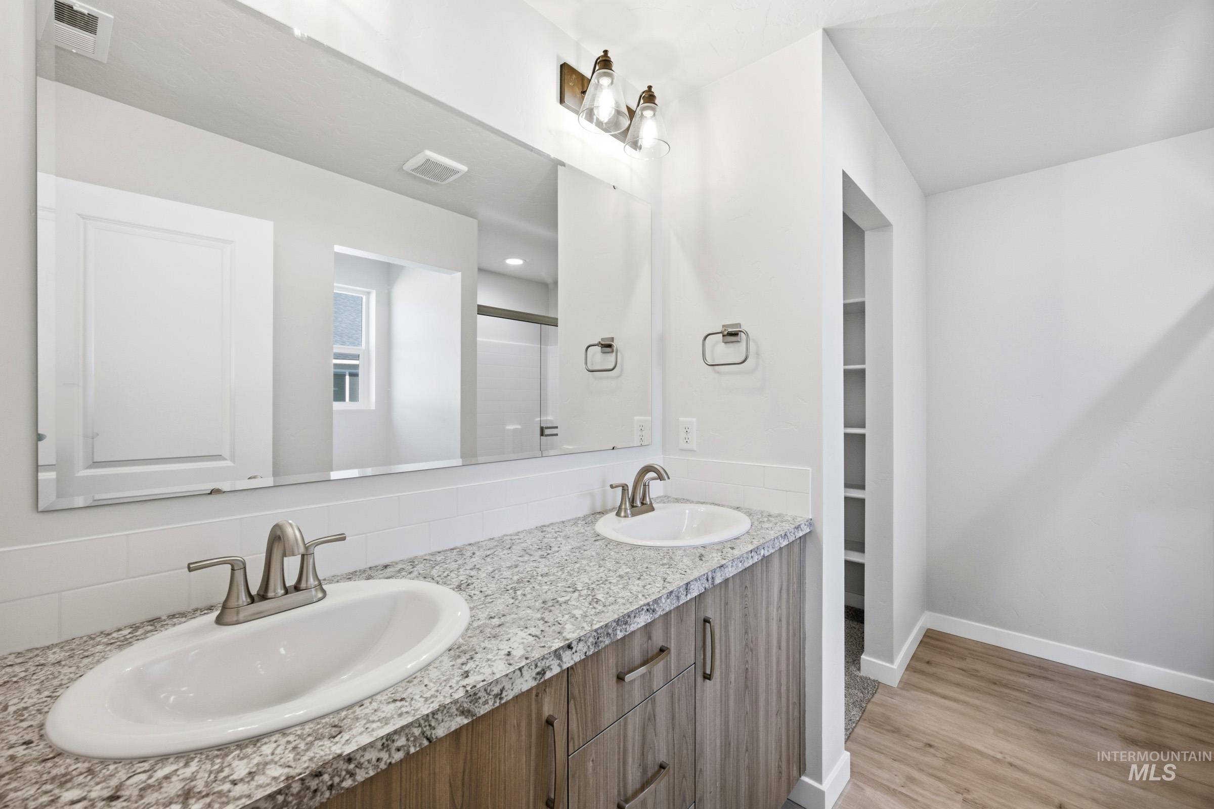 13298 Bank Street Caldwell, ID 83607 - Photo 13 of 23 Dual vanity with light-tone wood-finish cabinetry, granite-style countertops, and undermount sinks