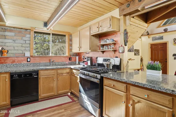 a kitchen with stainless steel appliances granite countertop a sink stove and cabinets