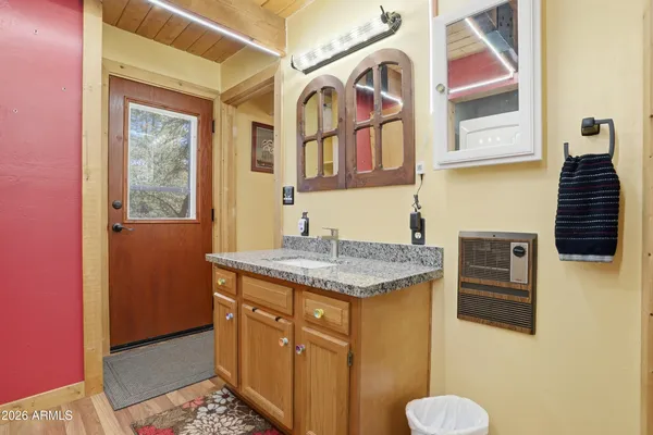 a bathroom with a granite countertop sink and a mirror