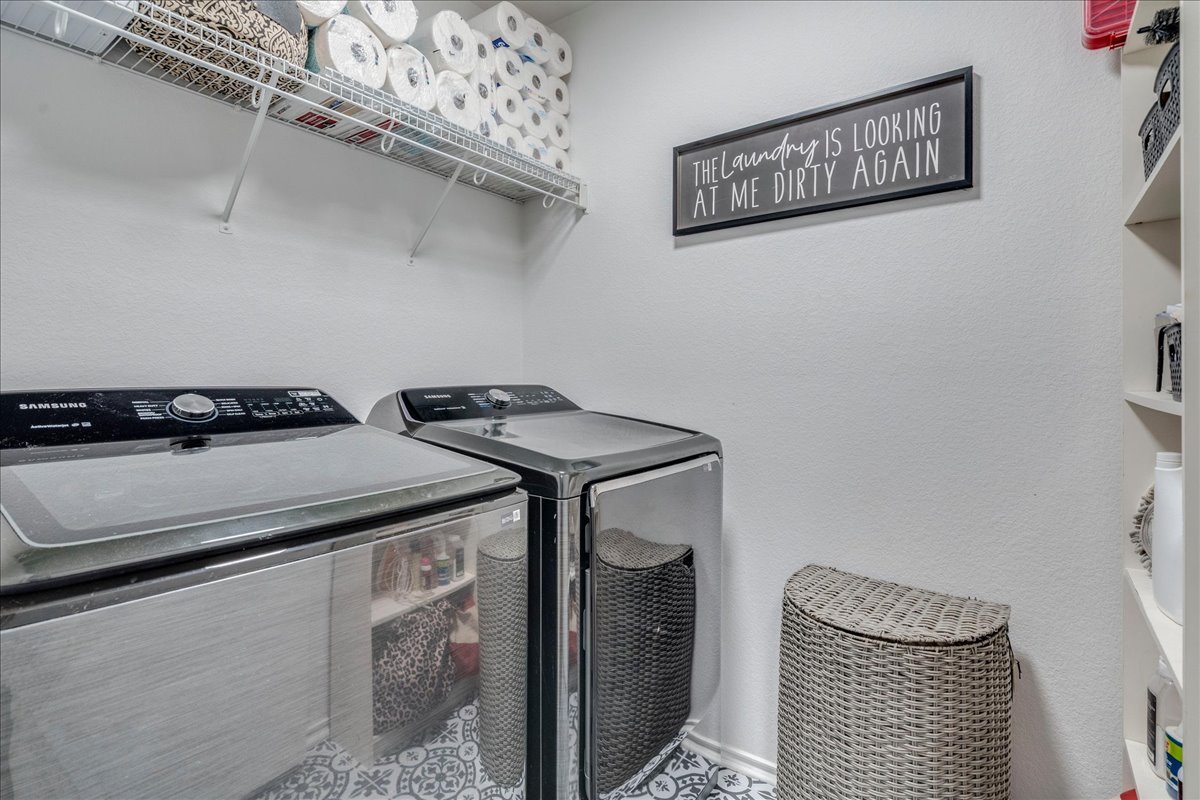 148 Buttercup Way Kyle, TX 78640 - Photo 23 of 33 Laundry room featuring washer and clothes dryer and a textured wall