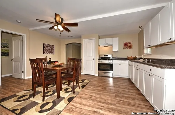 a large kitchen with cabinets wooden floor and stainless steel appliances