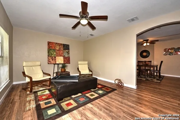 a living room with furniture and a wooden floor