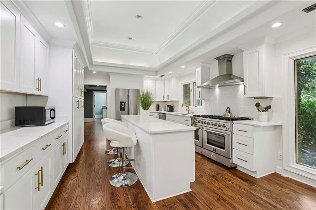 a kitchen with stainless steel appliances white cabinets a sink and a stove