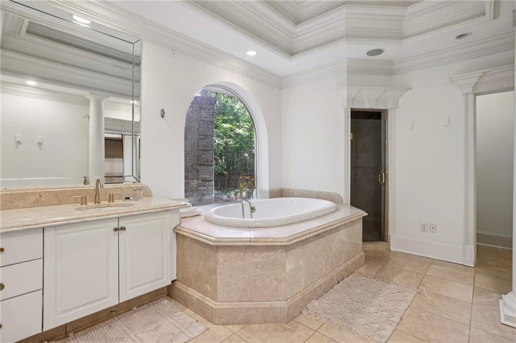 13039 Freemanville Road Alpharetta, GA 30004 - Photo 31 of 62 a spacious bathroom with a sink a mirror and a bathtub