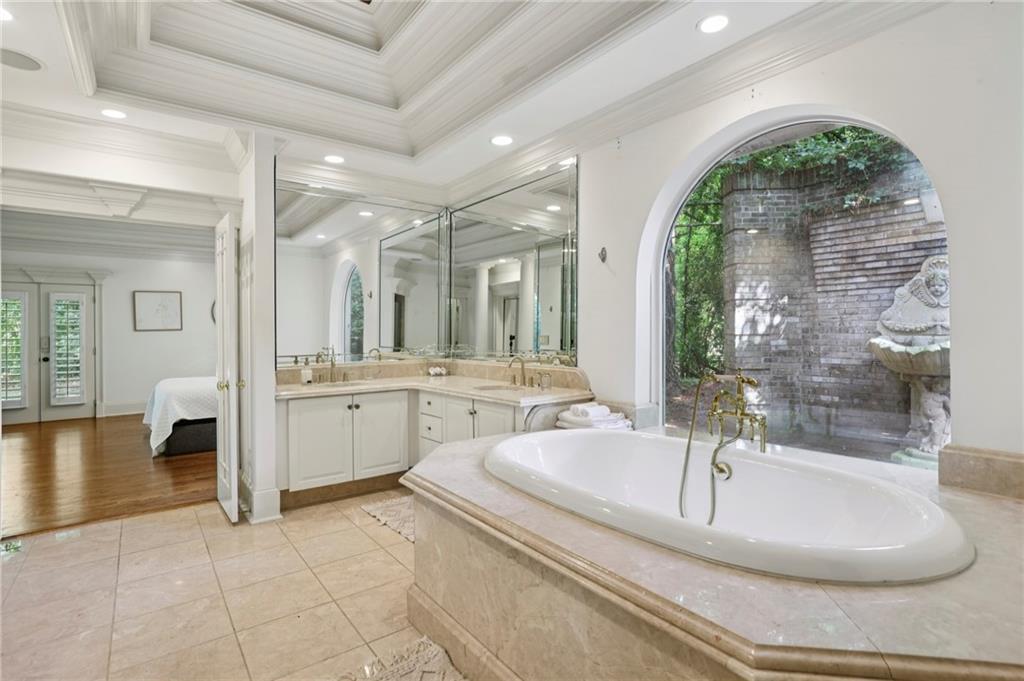 13039 Freemanville Road Alpharetta, GA 30004 - Photo 32 of 62 a bathroom with a tub a sink a mirror and a shower