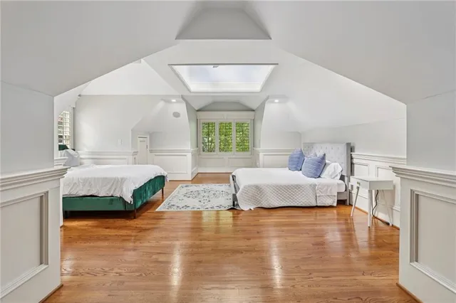 a spacious bedroom with a bed and wooden floor