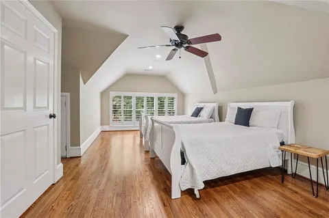 a living room with wooden floor and dining table with wooden floor