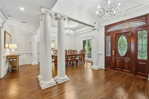 a living room with furniture a fireplace and a chandelier