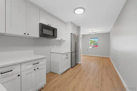 an empty room with a window and a fan