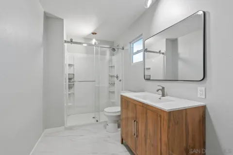 a view of a hallway with an entryway and livingroom with furniture