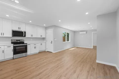 a view of an empty room with wooden floor & closet