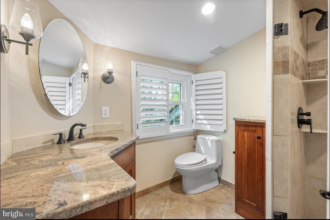 207 Anthony Wayne Drive Wayne, PA 19087 - Photo 31 of 47 a bathroom with a granite countertop sink a toilet a mirror and bathtub