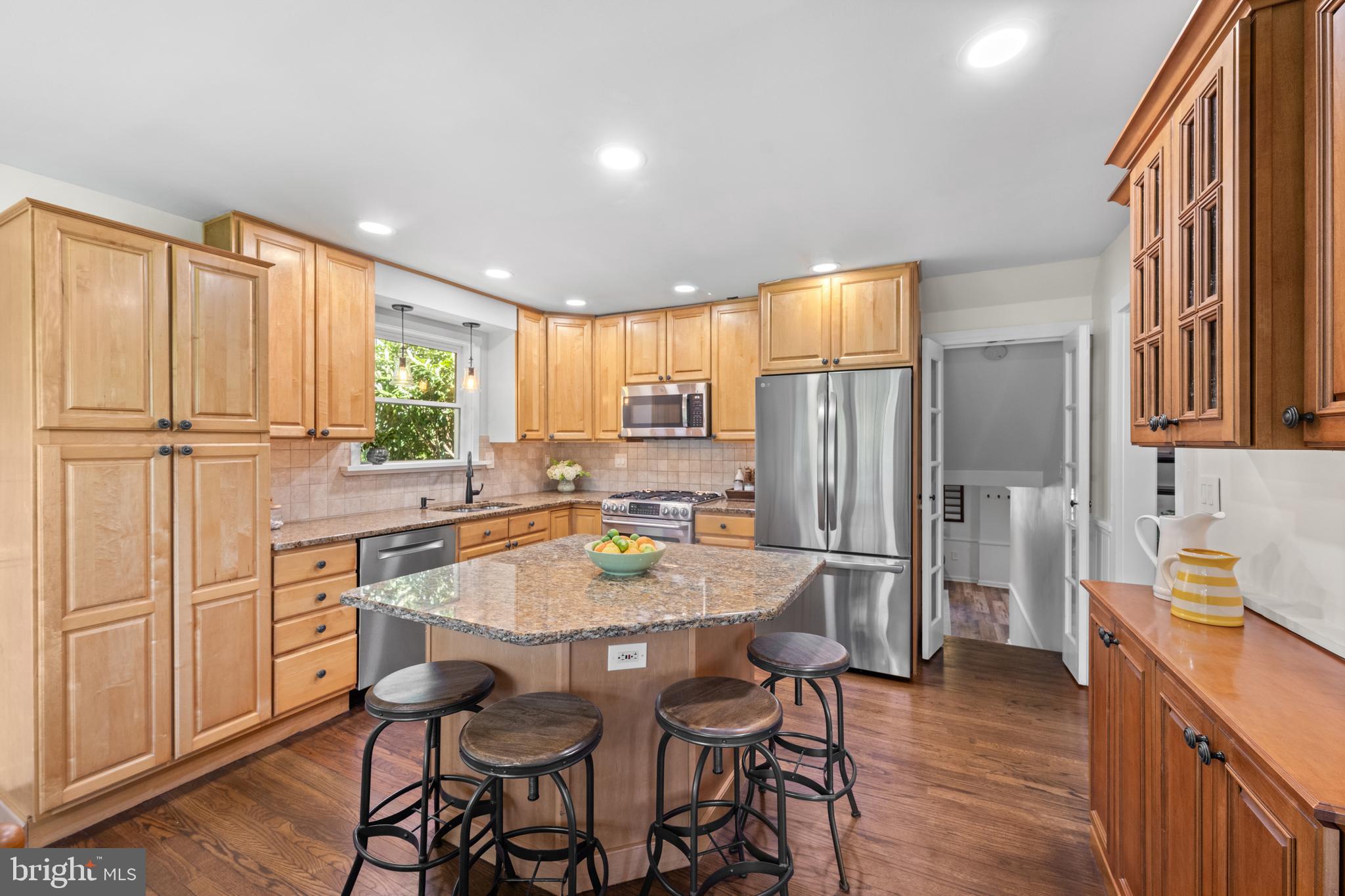 207 Anthony Wayne Drive Wayne, PA 19087 - Photo 8 of 47 a kitchen with stainless steel appliances granite countertop a stove a refrigerator a sink dishwasher and a dining table with wooden floor