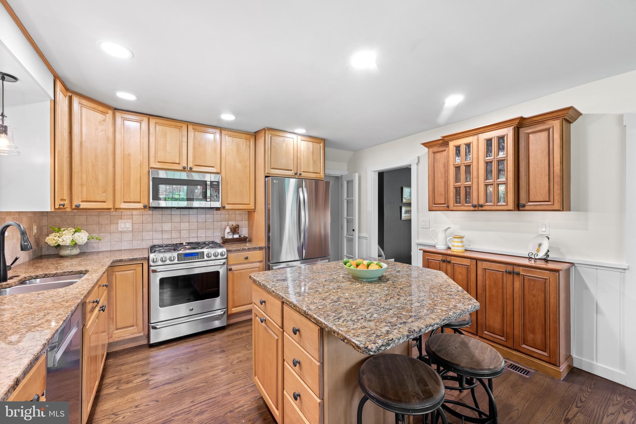 207 Anthony Wayne Drive Wayne, PA 19087 - Photo 9 of 47 a kitchen with stainless steel appliances granite countertop a stove top oven a sink dishwasher and wooden cabinets with wooden floor