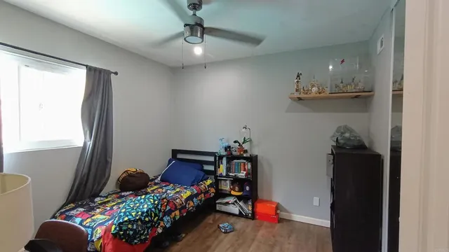 a bedroom with furniture and a chandelier fan