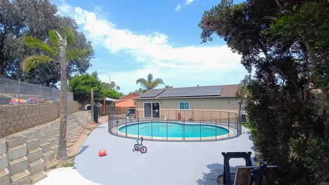 a view of a house with swimming pool and sitting area